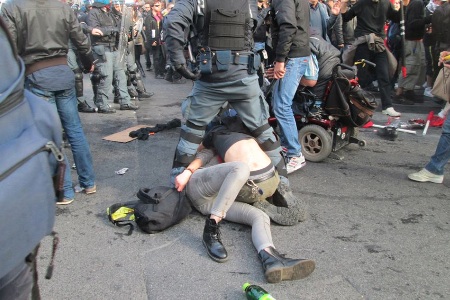 I due ragazzi bloccati e pestati per terra a Piazza Barberini durante la manifestazione del 12 aprile a Roma. Fotografia di Checchino Antonini
