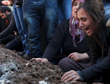 Relatives of Siyar Salman mourn over his grave during a funeral ceremony in the Kurdish dominated southeastern city of Diyarbakir, Turkey