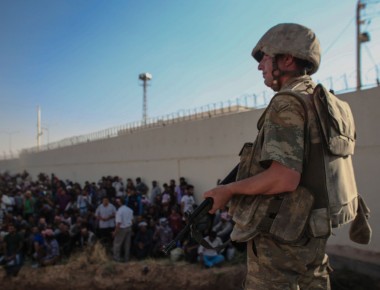 Un soldato turco controlla rifugiati siriani.
© Reuters