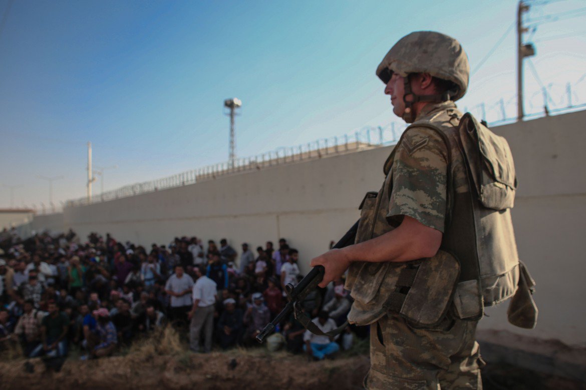 Un soldato turco controlla rifugiati siriani.
© Reuters