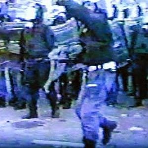 Adriano Lauro (il poliziotto in primo piano) lancia un sasso contro i manifestanti il 20 luglio 2001, a Genova 