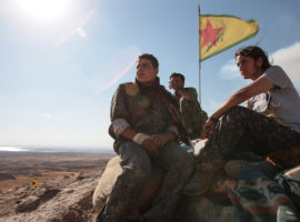KOBANE, SYRIA - JUNE 20: (TURKEY OUT) A Kurdish People's Protection Units, or YPG fighters stand near a check point in the outskirts of the destroyed Syrian town of Kobane, also known as Ain al-Arab, Syria. June 20, 2015. Kurdish fighters with the YPG took full control of Kobane and strategic city of Tal Abyad, dealing a major blow to the Islamic State group's ability to wage war in Syria. Mopping up operations have started to make the town safe for the return of residents from Turkey, after more than a year of Islamic State militants holding control of the town. (Photo by Ahmet Sik/Getty Images)
