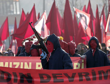 epa05079526 A masked member of an ultra leftist group brandishes an automatic weapon during the funeral of Yeliz Erbay and Sirin Oter, members of an ultra leftist party, killed by Turkish police in an anti-terror operation, in Istanbul, Turkey, 23 December 2015. According to local reports two members of the leftist group were killed and four police officers wounded, in an anti terror operation linked to a roadside bomb attack in Istanbul.  EPA/SEDAT SUNA