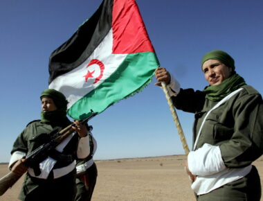 epa08817663 (FILE) - A Sahrawi woman soldier carries a flag of the Democratic Arab Republic of Sahara as another one looks on, during a parade  in Tifariti in the liberated territories of Western Sahara, 20 May 2008 (reissued 13 November 2020). The Moroccan Royal Armed Forces (FAR) on 13 November 2020 launched an operation to establish a 'security cordon' to control flow of people and goods across buffer zone on border linking Morocco to Mauritania. The Moroccan Foreign Ministry said the operation is meant to face the 'serious and unacceptable provocations' of the Polisario Front in the disputed territory of Guerguerat.  EPA/MOHAMED MESSARA