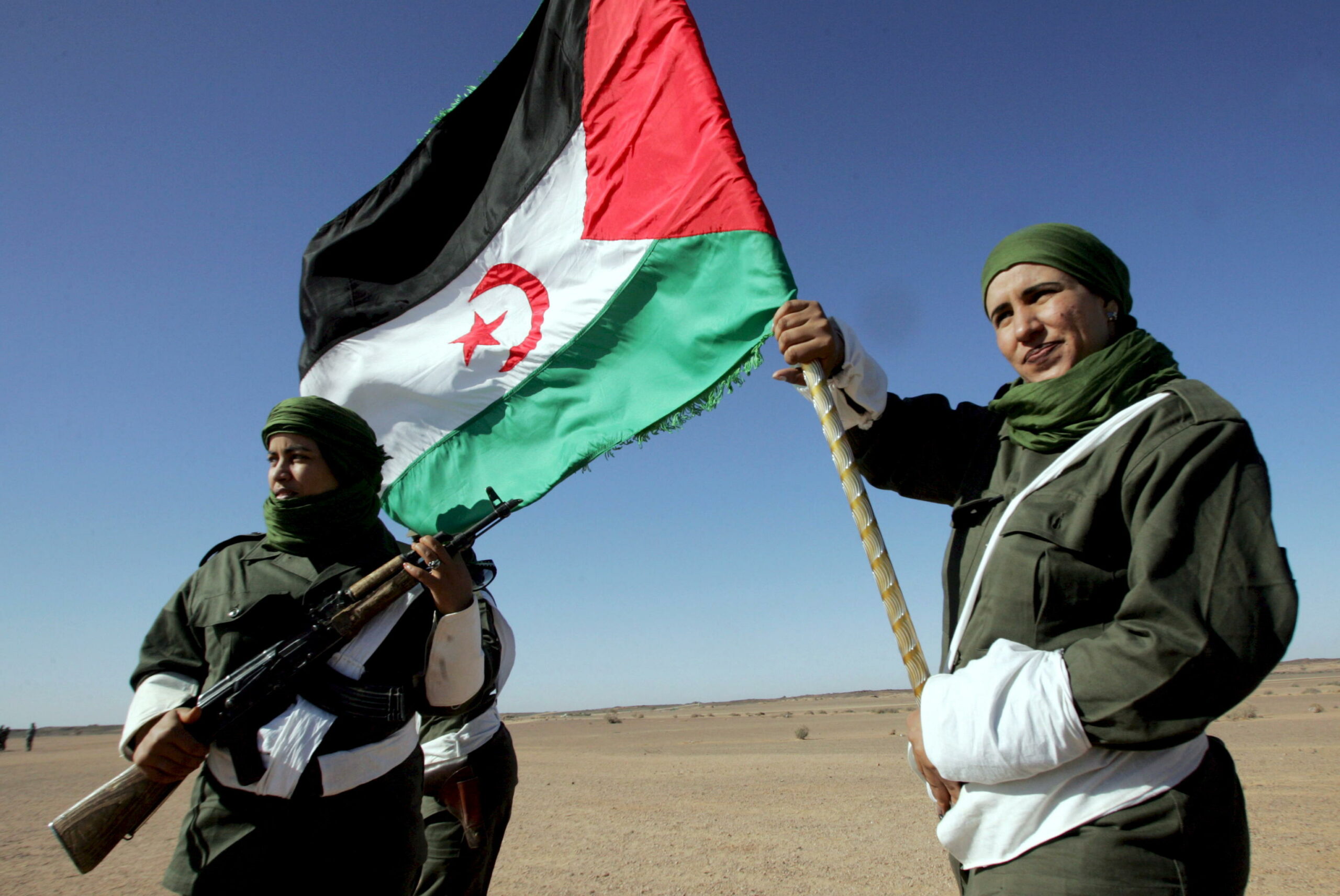 epa08817663 (FILE) - A Sahrawi woman soldier carries a flag of the Democratic Arab Republic of Sahara as another one looks on, during a parade  in Tifariti in the liberated territories of Western Sahara, 20 May 2008 (reissued 13 November 2020). The Moroccan Royal Armed Forces (FAR) on 13 November 2020 launched an operation to establish a 'security cordon' to control flow of people and goods across buffer zone on border linking Morocco to Mauritania. The Moroccan Foreign Ministry said the operation is meant to face the 'serious and unacceptable provocations' of the Polisario Front in the disputed territory of Guerguerat.  EPA/MOHAMED MESSARA