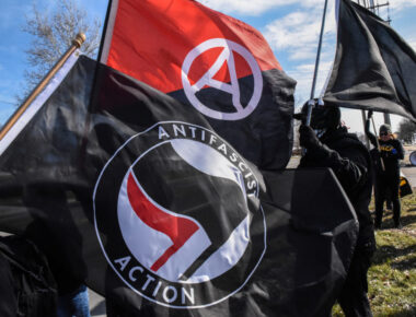 Members of the Great Lakes anti-fascist organization (Antifa) fly flags during a protest against the Alt-right outside a hotel in Warren, Michigan, U.S., March 4, 2018. REUTERS/Stephanie Keith