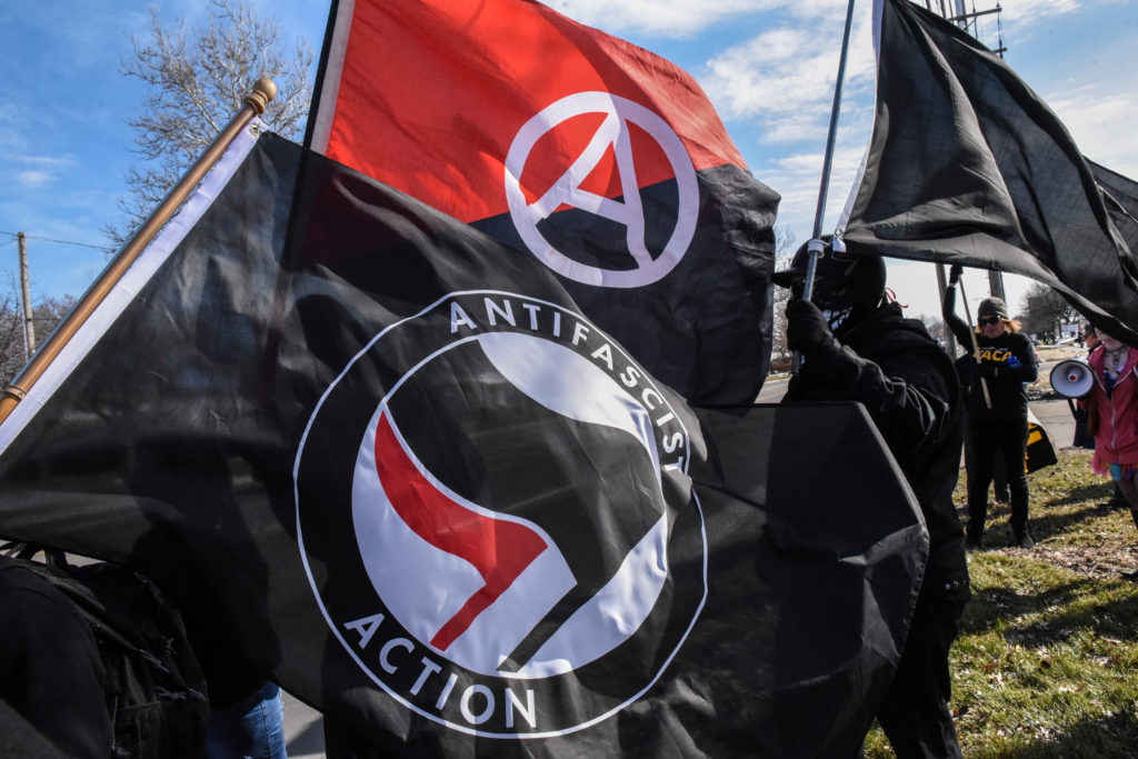 Members of the Great Lakes anti-fascist organization (Antifa) fly flags during a protest against the Alt-right outside a hotel in Warren, Michigan, U.S., March 4, 2018. REUTERS/Stephanie Keith
