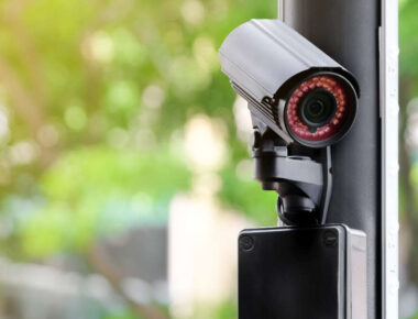 Modern public CCTV camera on a electric pole with blurred natural background. Intelligent reccording cameras for monitoring all day and night. Concept of surveillance and monitoring with copy space.