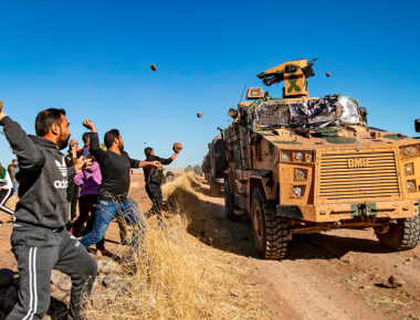 TOPSHOT - Kurdish demonstrators hurl rocks at a Turkish military vehicle on November 8, 2019, during a joint Turkish-Russian patrol near the town of Al-Muabbadah in the northeastern part of Hassakah on the Syrian border with Turkey. (Photo by Delil SOULEIMAN / AFP) (Photo by DELIL SOULEIMAN/AFP via Getty Images)